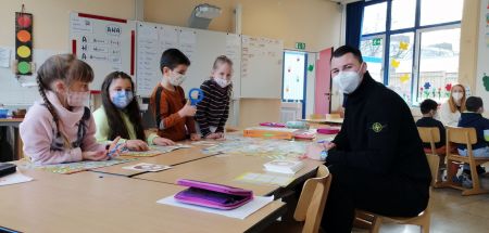 Zu sehen sind Grundschulkinder beim spielerischen Deutschlernen mit einem Sprachlernbegleiter